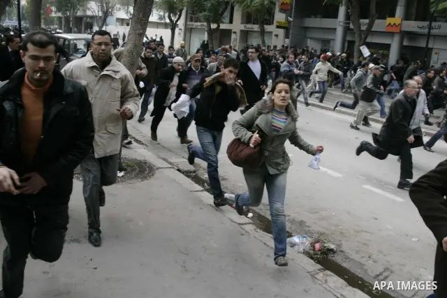 Protestors run away from tear gas as protests still going on in Tunis 4 days after the Depature of the Tunisian President Zine El Abidine Ben Ali to Saudi Arabia, Tunisia, 18 January 2011. Tunisian protesters called for...