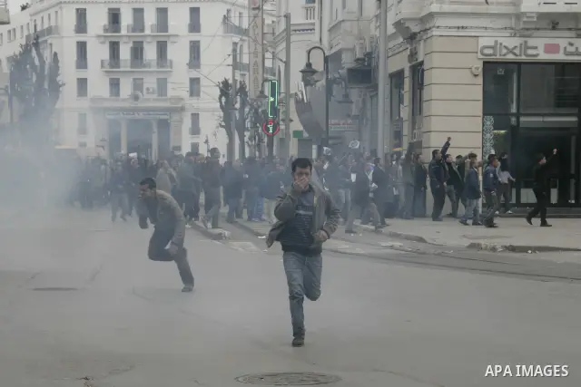 Tunisians run away as police use tear gas during a demonstration against Tunisia's ruling Constitutional Democratic Rally party (RCD) in the center of Tunis, Jan. 18. 2011. Tunisian interim president Foued Mebazaa and Pr...