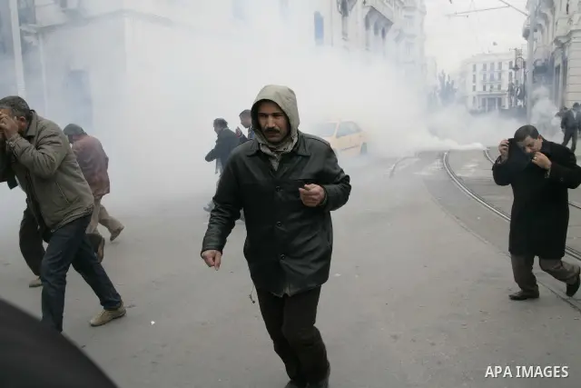 Tunisians run away as police use tear gas during a demonstration against Tunisia's ruling Constitutional Democratic Rally party (RCD) in the center of Tunis, Jan. 18. 2011. Tunisian interim president Foued Mebazaa and Pr...