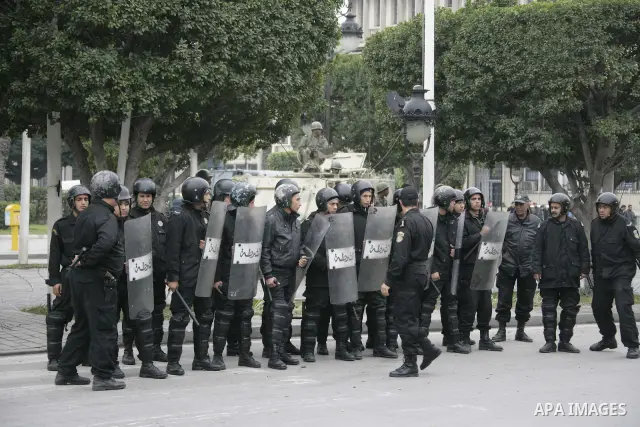 Tunisian policemen face protesters during a demonstration against the former ruling party Constitutional Democratic Rally (RCD) in central Tunis, Tunisia, 18 January 2011. Tunisia's reappointed Prime Minister Mohamed Gha...
