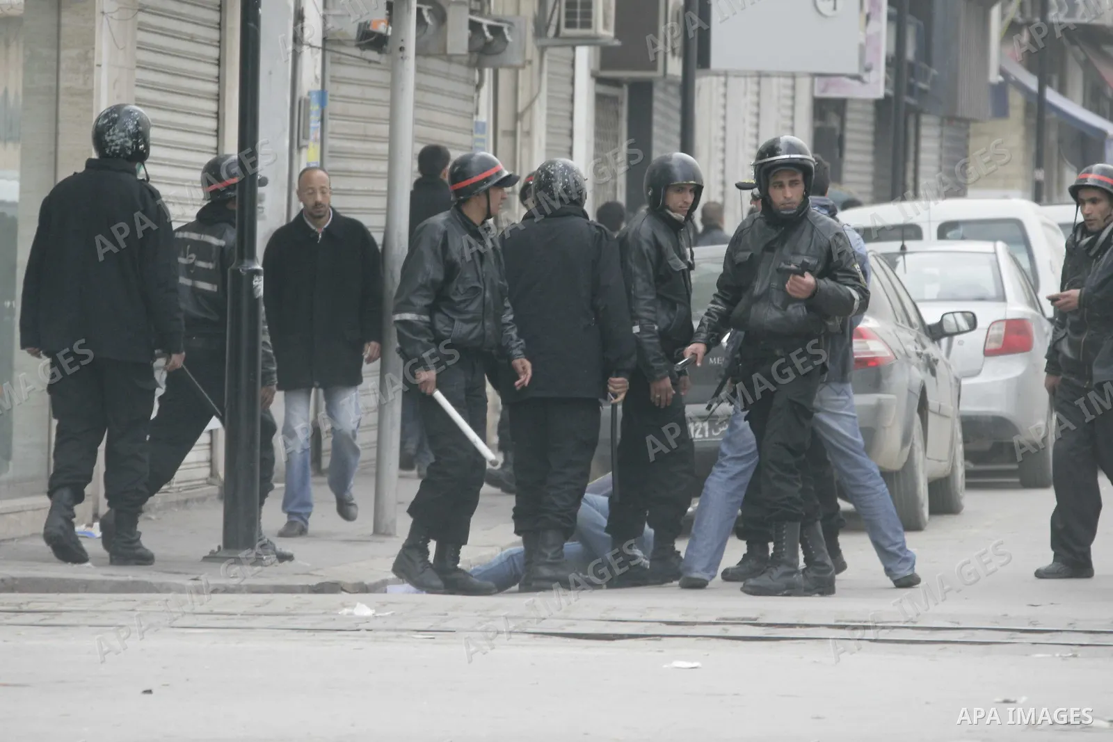 Tunisian policemen face protesters during a demonstration against the former ruling party Constitutional Democratic Rally (RCD) in central Tunis, Tunisia, 18 January 2011. Tunisia's reappointed Prime Minister Mohamed Gha...