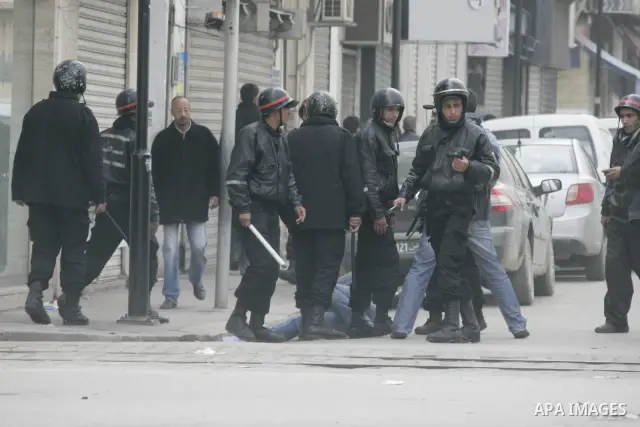 Tunisian policemen face protesters during a demonstration against the former ruling party Constitutional Democratic Rally (RCD) in central Tunis, Tunisia, 18 January 2011. Tunisia's reappointed Prime Minister Mohamed Gha...