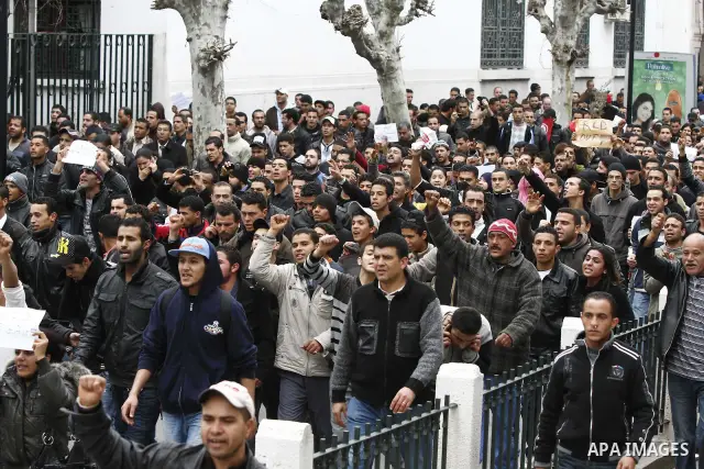 Tunisians take part in a demonstration against Tunisia's ruling Constitutional Democratic Rally party (RCD) in the center of Tunis, Jan. 18. 2011. Tunisian interim president Foued Mebazaa and Prime Minister Mohammed Ghan...