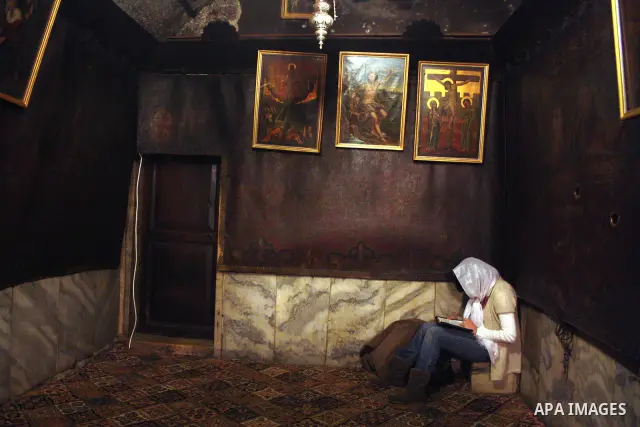 Clergy woman pray in the grotto in the Church of the Nativity, the site revered as the birthplace of Jesus, in the West Bank town of Bethlehem, ahead of the Eastern Orthodox Christmas January 19, 2011. Photo by Najeh Has...