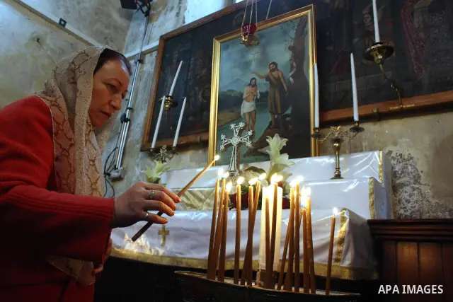 A worshipper lights a candle in the Church of the Nativity, the site revered as the birthplace of Jesus, in the West Bank town of Bethlehem, ahead of the Eastern Orthodox Christmas January 19, 2011. Photo by Najeh Hashla...