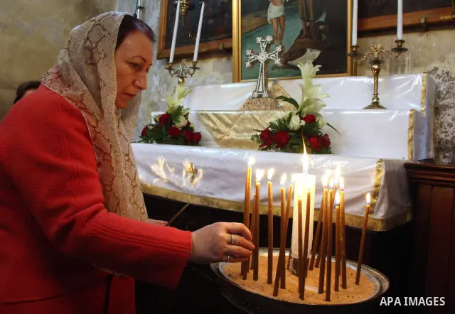 A worshipper lights a candle in the Church of the Nativity, the site revered as the birthplace of Jesus, in the West Bank town of Bethlehem, ahead of the Eastern Orthodox Christmas January 19, 2011. Photo by Najeh Hashla...