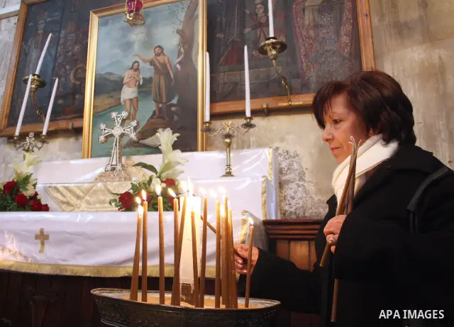 A worshipper lights a candle in the Church of the Nativity, the site revered as the birthplace of Jesus, in the West Bank town of Bethlehem, ahead of the Eastern Orthodox Christmas January 19, 2011. Photo by Najeh Hashla...