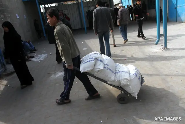 Palestinians receive aid flour sacks from a UN Relief and Works Agency (UNRWA) warehouse in Gaza city, on Jan. 19, 2011. Photo by Ashraf Amra