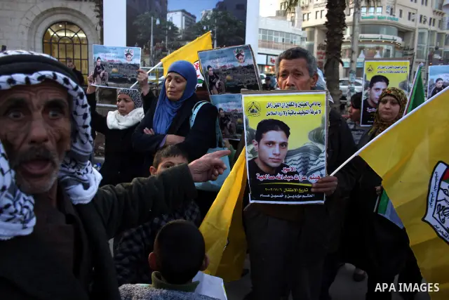 Palestinians carry a picture Haitham Ezzat Salheyah prisoner in the West Bank city of Ramallah January 19, 2011, the prisoner escaped an assassination attempt by the Israeli "Shabak" through customer tried to tuck a pill...