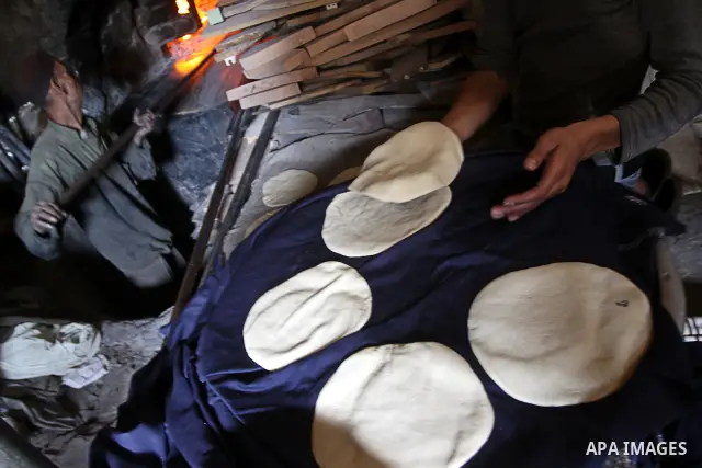 A Palestinian baker prepares loaves of bread at his traditional bakery in Gaza City on Jan. 20, 2011. The flour is running out and there will be a crisis within two days because of Israel's refused to allow some flour to...