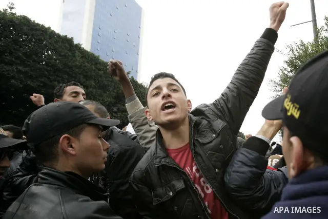 Tunisians take part in a protest in front of the headquarters of the Constitutional Democratic Rally (RCD) party of ousted president Zine al-Abidine Ben Ali during a demonstration in downtown Tunis, January 20, 2011. Tun...
