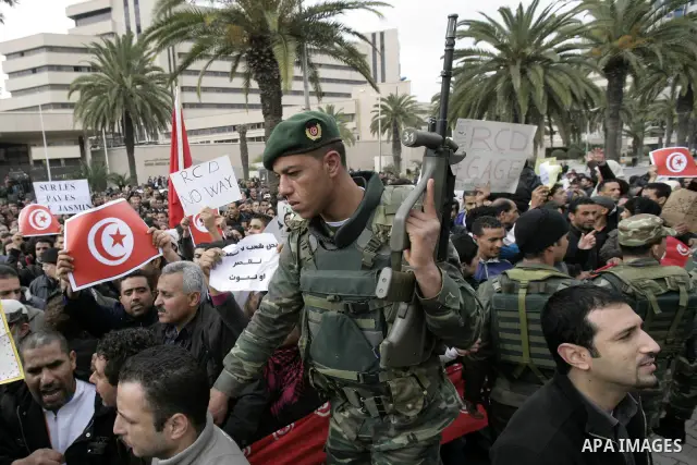 Tunisians take part in a protest in front of the headquarters of the Constitutional Democratic Rally (RCD) party of ousted president Zine al-Abidine Ben Ali during a demonstration in downtown Tunis, January 20, 2011. Tun...