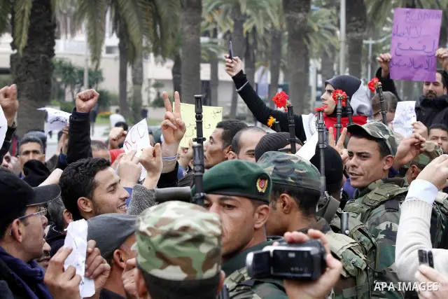 Tunisians take part in a protest in front of the headquarters of the Constitutional Democratic Rally (RCD) party of ousted president Zine al-Abidine Ben Ali during a demonstration in downtown Tunis, January 20, 2011. Tun...