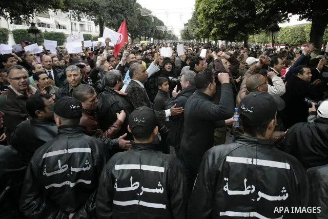 Tunisians take part in a protest in front of the headquarters of the Constitutional Democratic Rally (RCD) party of ousted president Zine al-Abidine Ben Ali during a demonstration in downtown Tunis, January 20, 2011. Tun...