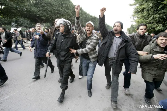 Tunisians take part in a protest in front of the headquarters of the Constitutional Democratic Rally (RCD) party of ousted president Zine al-Abidine Ben Ali during a demonstration in downtown Tunis, January 20, 2011. Tun...