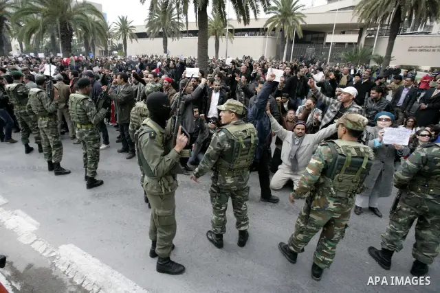 Tunisians take part in a protest in front of the headquarters of the Constitutional Democratic Rally (RCD) party of ousted president Zine al-Abidine Ben Ali during a demonstration in downtown Tunis, January 20, 2011. Tun...