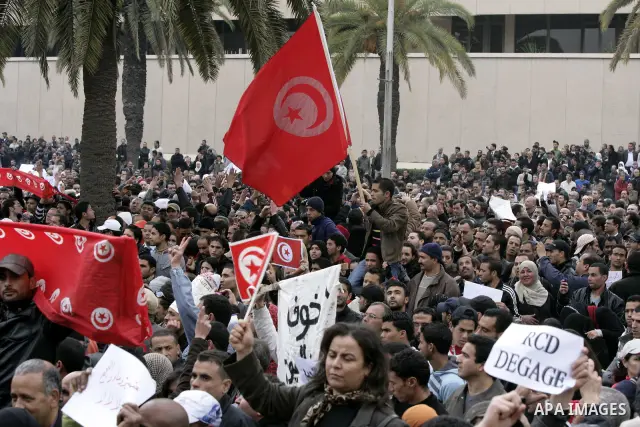 Tunisians take part in a protest in front of the headquarters of the Constitutional Democratic Rally (RCD) party of ousted president Zine al-Abidine Ben Ali during a demonstration in downtown Tunis, January 20, 2011. Tun...