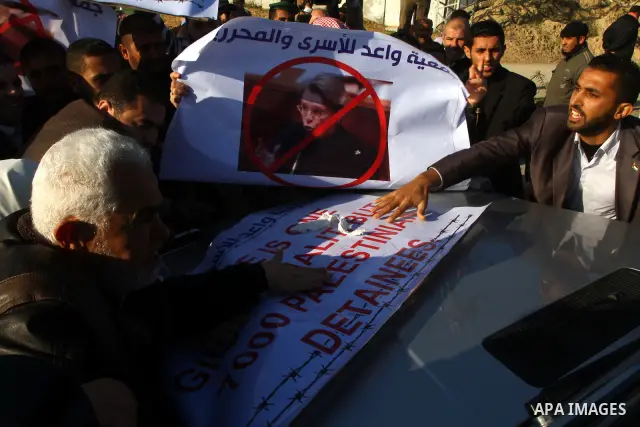 Palestinian relatives of a prisoners jailed in Israel hold posters as they block the vehicle carrying French Foreign Minister Michele Alliot-Marie as it makes its way into Gaza Strip, on the Palestinian side of the Erez...