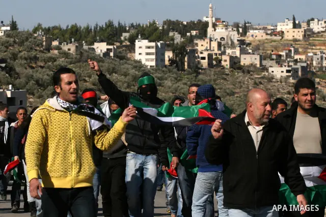 Palestinian protesters take part in a demonstration against the expansion of the nearby Jewish settlement of Halamish in the West Bank village of Nabi Saleh, near Ramallah, Friday, Jan. 21, 2011. Photo by Issam Rimawi