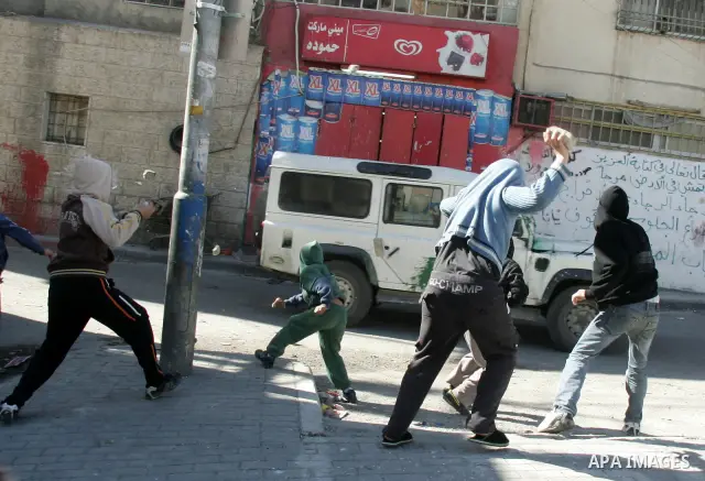 Masked Palestinian youths prepare to throw stones at Israeli forces during clashes in the Arab east Jerusalem neighbourhood of Silwan on January 21, 2011. Photo by Mahfouz Abu Turk