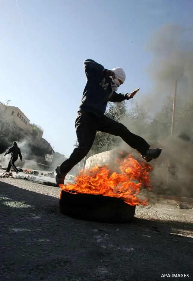 Masked Palestinian youths prepare to throw stones at Israeli forces during clashes in the Arab east Jerusalem neighbourhood of Silwan on January 21, 2011. Photo by Mahfouz Abu Turk