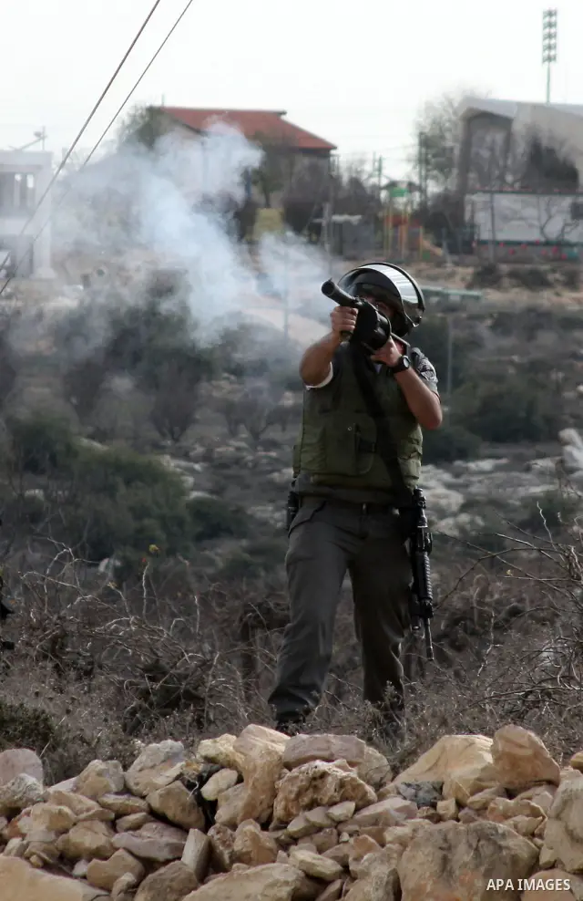 An Israeli soldier fires tear gas canister towards demonstrators during a protest by Palestinian, Israeli and foreign activists against the demolishing of farm land to be used in the construction of Jewish settlements ne...