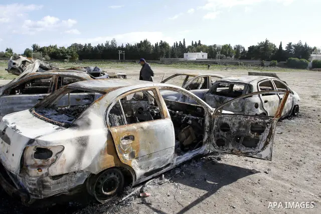 Burned cars are seen on a street in Carthage, outside Tunis, January 22, 2011.A Tunisian prosecutor opened an investigation into the overseas assets of the ousted president and his deeply resented family Wednesday, as th...