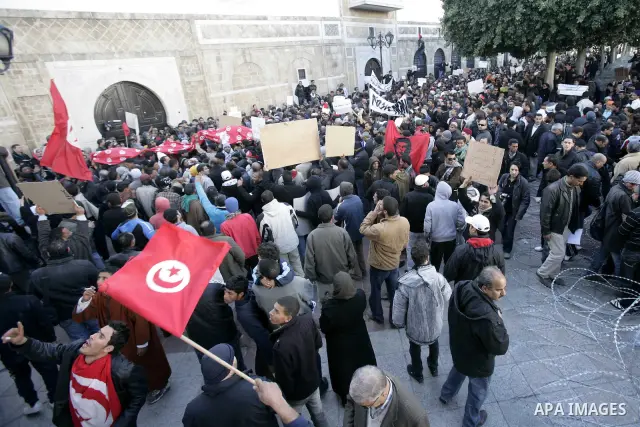 Tunisians hold placards during a demonstration to demand a new government free of officials of the ousted regime of former president Zine el Abidine Ben Ali, goes on in central Tunis, Tunisia, 23 January 2011. According...