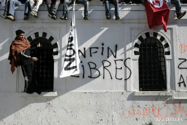 Tunisians hold placards during a demonstration to demand a new government free of officials of the ousted regime of former president Zine el Abidine Ben Ali, goes on in central Tunis, Tunisia, 23 January 2011. According...