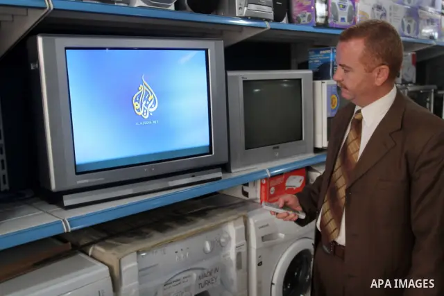 A Palestinian man watchs Al-Jazeera channel at his shop, in Gaza City on Jan. 24, 2011. Al-Jazeera yesterday, revealed leaked documents recorded during the negotiations that occur between the Palestinian Authority and th...