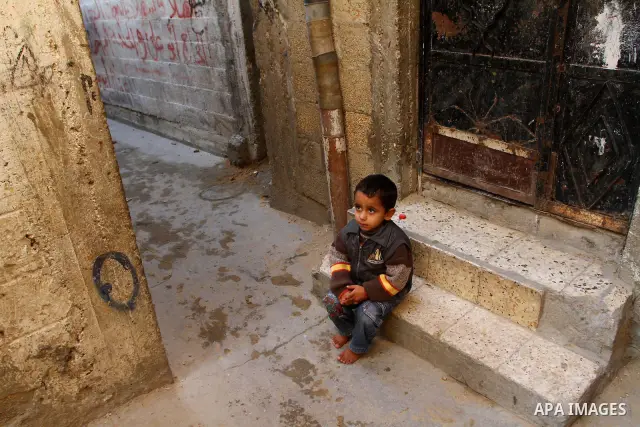 A Palestinian refugee boy sits in front of his home in the Jabalia refugee camp in the northern Gaza Strip on January 24, 2011 a day after leaked documents were published by Al-Jazeera and the British newspaper the Guard...