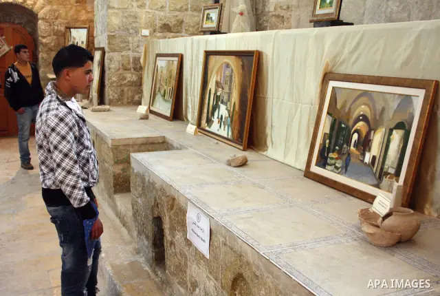 Visitors look at callgraphic works during the opening of the ( Old City Museum ) in the old city of the West Bank city of Hebron on January 25, 2011. The museum located in " Haret Dari " near the Khan al-Khalil, it was o...