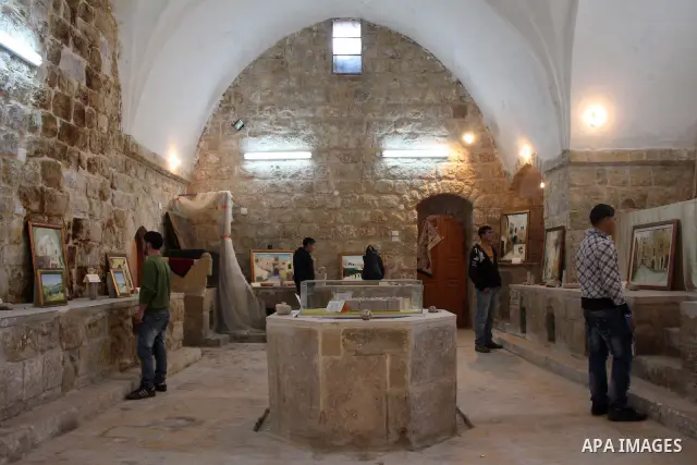 Visitors look at callgraphic works during the opening of the ( Old City Museum ) in the old city of the West Bank city of Hebron on January 25, 2011. The museum located in " Haret Dari " near the Khan al-Khalil, it was o...
