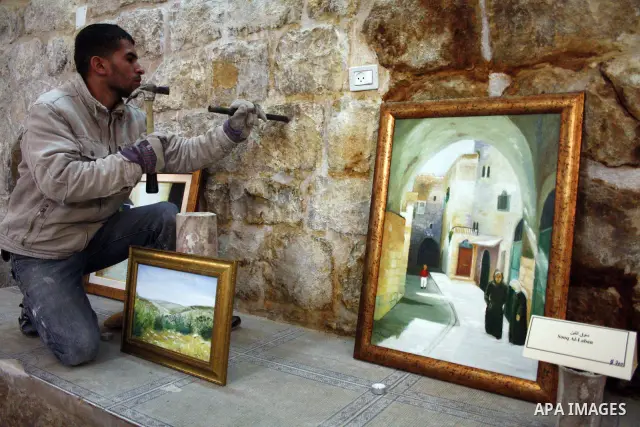 A Palestinian laborer works near a callgraphic works during the opening of the ( Old City Museum ) in the old city of the West Bank city of Hebron on January 25, 2011. The museum located in " Haret Dari " near the Khan a...