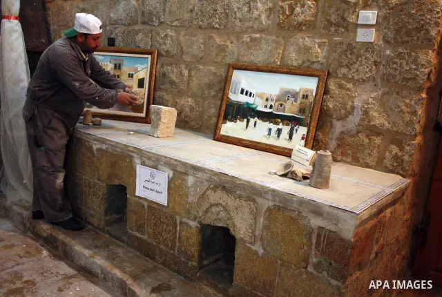 A Palestinian laborer works near a callgraphic works during the opening of the ( Old City Museum ) in the old city of the West Bank city of Hebron on January 25, 2011. The museum located in " Haret Dari " near the Khan a...