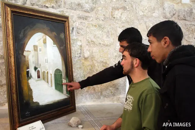 Visitors look at callgraphic works during the opening of the ( Old City Museum ) in the old city of the West Bank city of Hebron on January 25, 2011. The museum located in " Haret Dari " near the Khan al-Khalil, it was o...