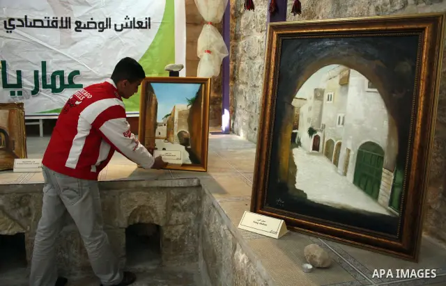 A Palestinian laborer works near a callgraphic works during the opening of the ( Old City Museum ) in the old city of the West Bank city of Hebron on January 25, 2011. The museum located in " Haret Dari " near the Khan a...