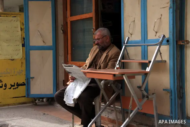 A Palestinian man reads the newspaper in alley in the Balata refugee camp in the northern West Bank city of Nablus on January 25, 2011, a day after it was leaked by Al-Jazeera in revealed documents that Palestinian negot...