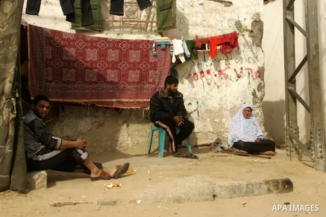 Palestinians sit in front their home in alley in the Rafah refugee camp in the southern Gaza Strip on January 25, 2011, a day after it was leaked by Al-Jazeera in revealed documents that Palestinian negotiators accepted...