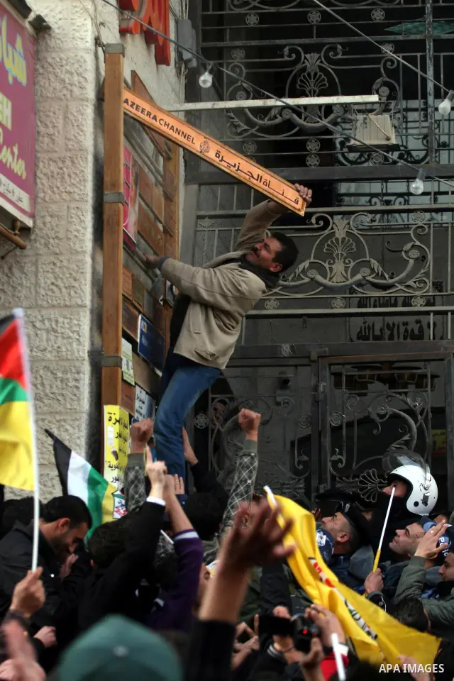 Palestinians supporters of the President Mahmoud Abbas gather next to Al-Jazeera office in the West Bank town of Ramallah, to protest against Al-Jazeera TV Channel on 25 January 2011. Palestinian negotiators privately ag...