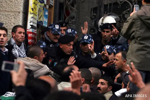 Palestinians supporters of the President Mahmoud Abbas gather next to Al-Jazeera office in the West Bank town of Ramallah, to protest against Al-Jazeera TV Channel on 25 January 2011. Palestinian negotiators privately ag...