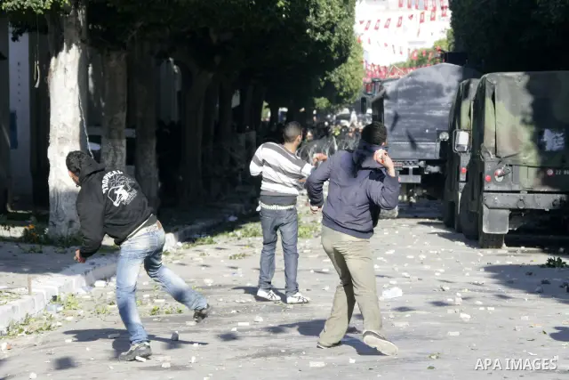 Tunisian youths hurl stones towards policemen during a demonstration against Prime Minister Mohammed Ghannouchi in front of the government palace in Tunis.Tunisia, 26 January 2011, Hundreds of defiant Tunisians camped in...