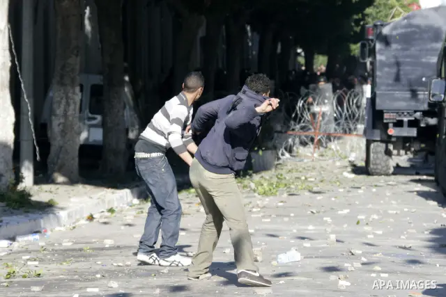 Tunisian youths hurl stones towards policemen during a demonstration against Prime Minister Mohammed Ghannouchi in front of the government palace in Tunis.Tunisia, 26 January 2011, Hundreds of defiant Tunisians camped in...