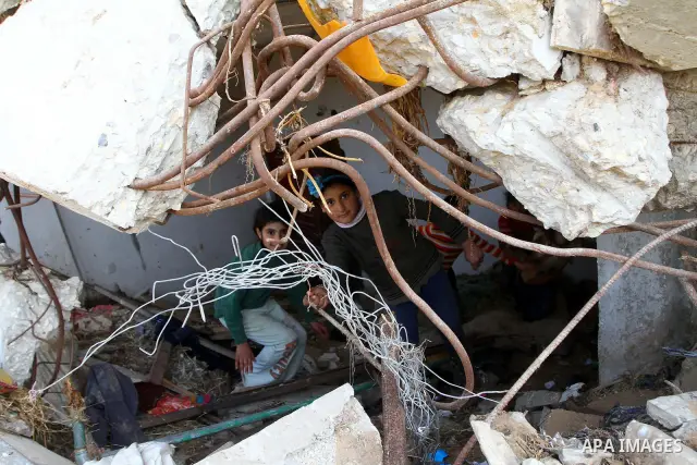 Palestinian children play outside their home which were partially destroyed during the Israeli war on Gaza in Jabalya in the northern Gaza Strip Jan. 26, 2011. a day after leaked documents were published by Al-Jazeera, s...