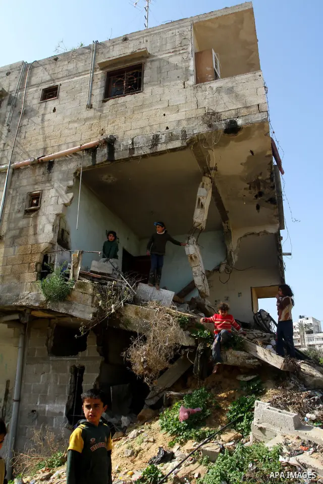 Palestinian children play outside their home which were partially destroyed during the Israeli war on Gaza in Jabalya in the northern Gaza Strip Jan. 26, 2011. a day after leaked documents were published by Al-Jazeera, s...