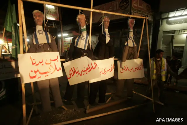 Palestinian Hamas activists take part rally against Abbas, following a recent broadcast by Al-Jazeera reportedly linking him to making broad concessions to Israel in peace talks, in Rafah, southern Gaza Strip, Wednesday,...