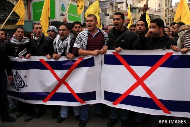 Palestinians hold Al-Jazeera logos printed in an Israeli flag during a rally in the West Bank City of Nablus , to protest against Al-Jazeera TV Channel on 27 January 2011. Al-Jazeera, a Qatar-based Arab satellite station...