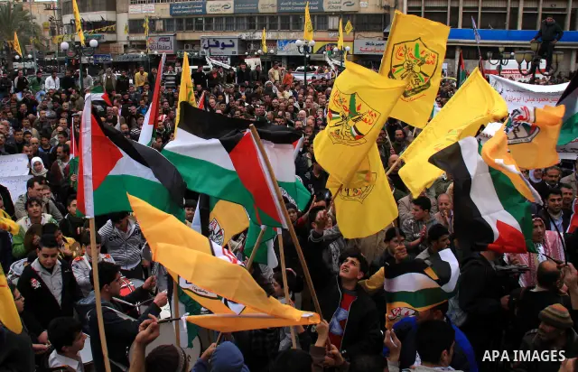 Palestinians hold Fatah flags and national flags during a rally in the West Bank City of Nablus , to protest against Al-Jazeera TV Channel on 27 January 2011. Al-Jazeera, a Qatar-based Arab satellite station, this week p...