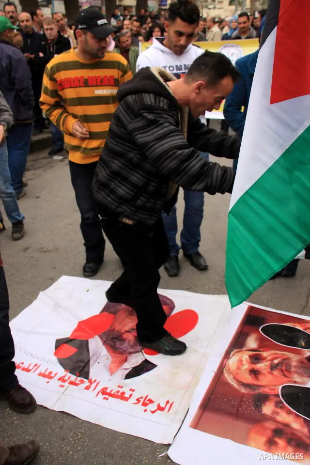 Palestinian Fatah activists burn posters of Palestinian Hamas leaders Khaled Meshaal and Mahmoud Zahar covered by printed footsteps during a rally in the West Bank City of Nablus , to protest against Al-Jazeera TV Channe...