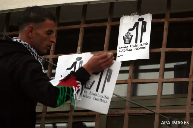 A Palestinian youth pastes placards denouncing Al-Jazeera during a protest near the offices of the pan-Arab news channel in the West Bank city of Ramallah on January 27, 2011. Al-Jazeera, a Qatar-based Arab satellite sta...